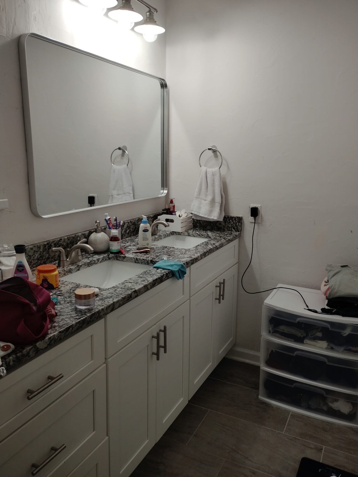 Bathroom vanity cluttered with toiletries before cleaning