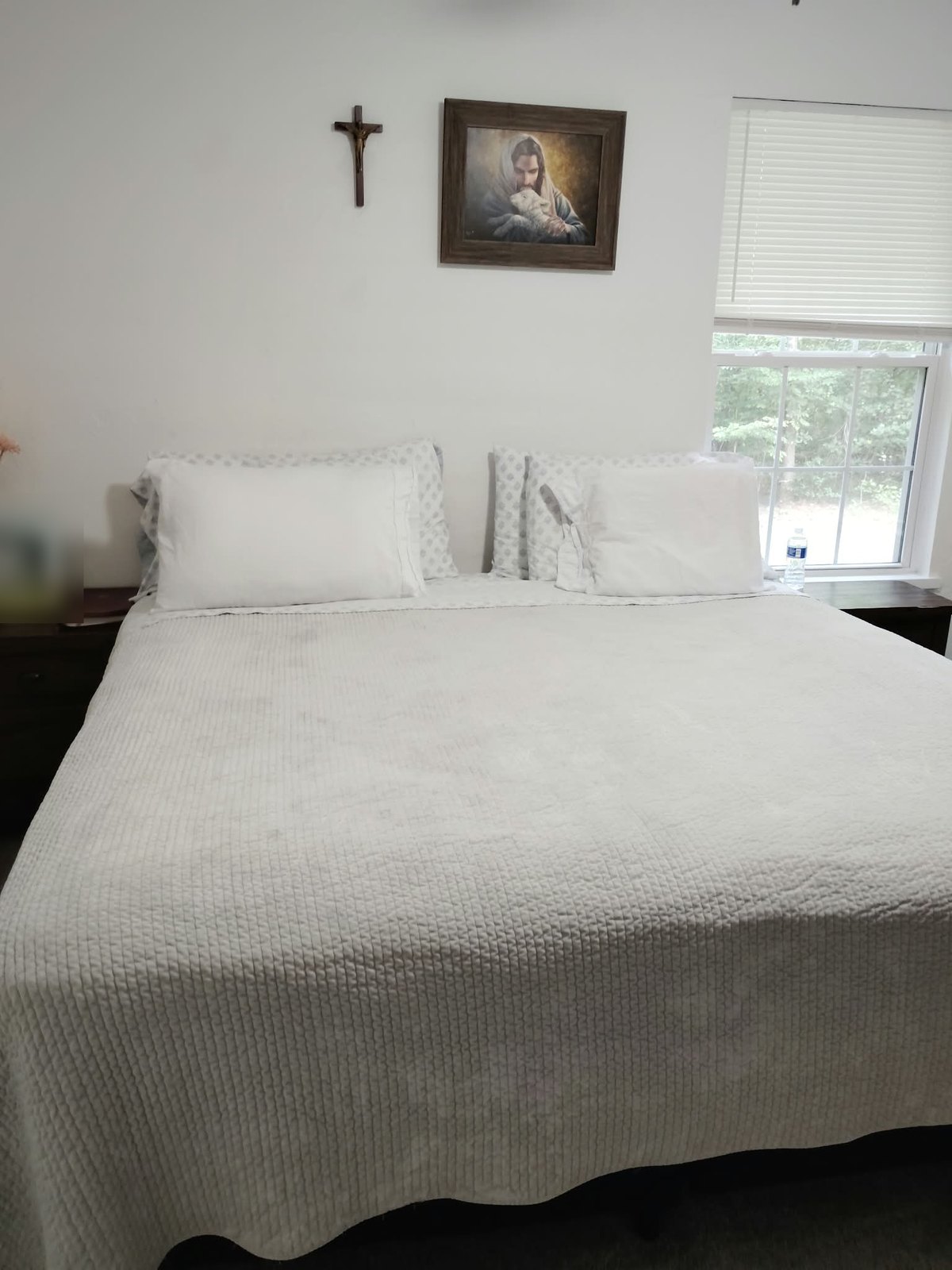 The same room with the bed made and surfaces cleared
